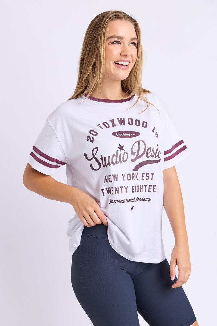 Woman wearing a white t-shirt with text and navy leggings on a white background