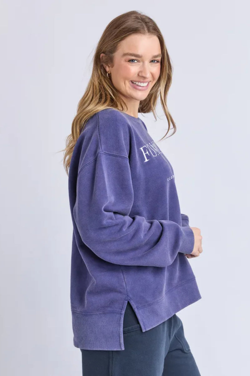 Woman wearing a purple sweatshirt with text on a light gray background