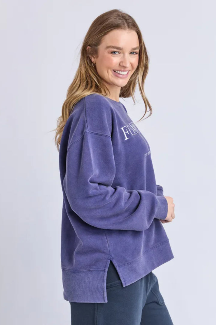 Woman wearing a purple sweatshirt with text on a light gray background