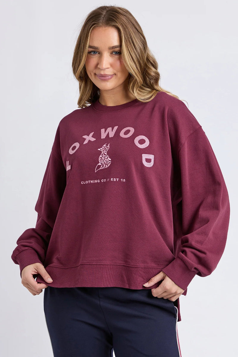 Person wearing a maroon sweatshirt with 'OXWOOD' branding on a light gray background