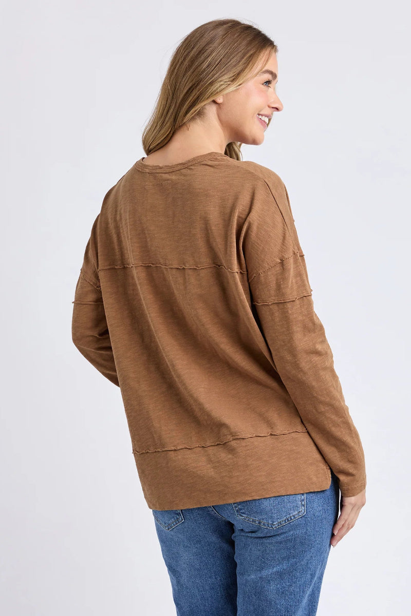 Woman wearing a brown jacket and blue jeans on a white background