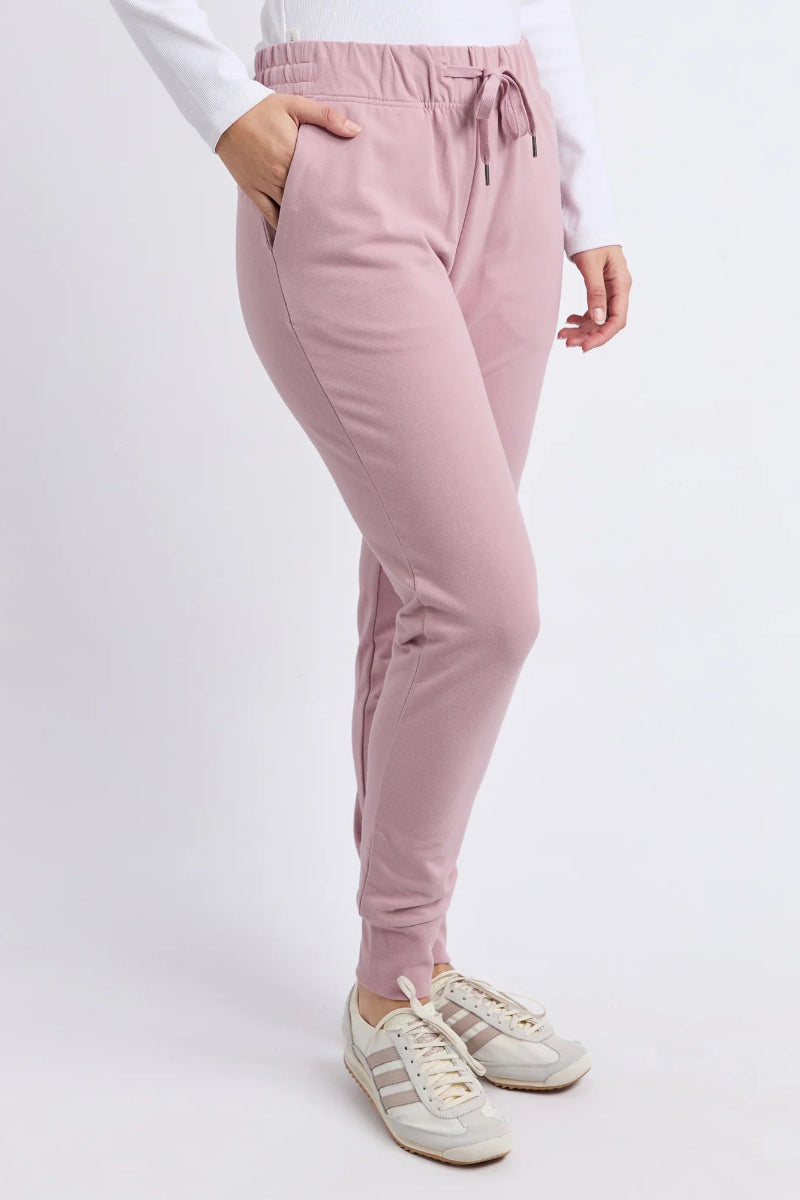 Pink jogger pants worn by a person on a white background