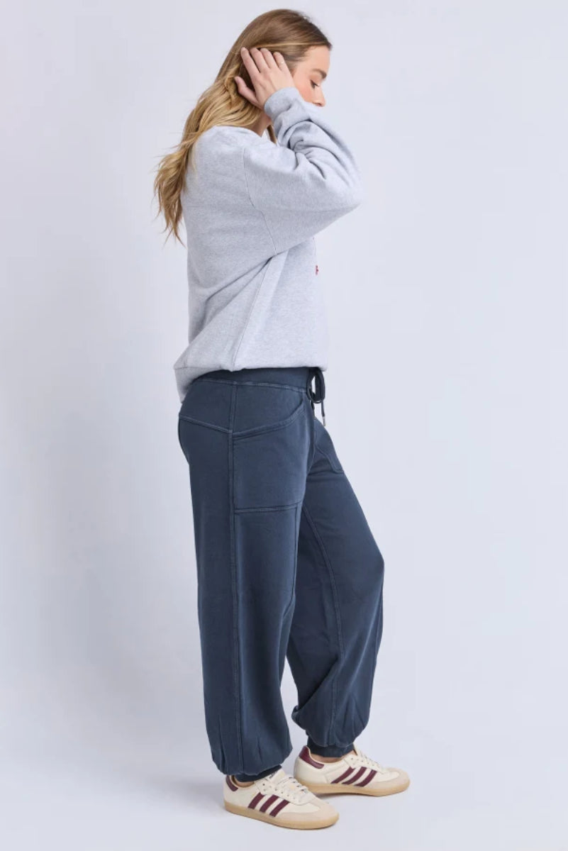 Person wearing a gray sweatshirt and blue pants on a white background
