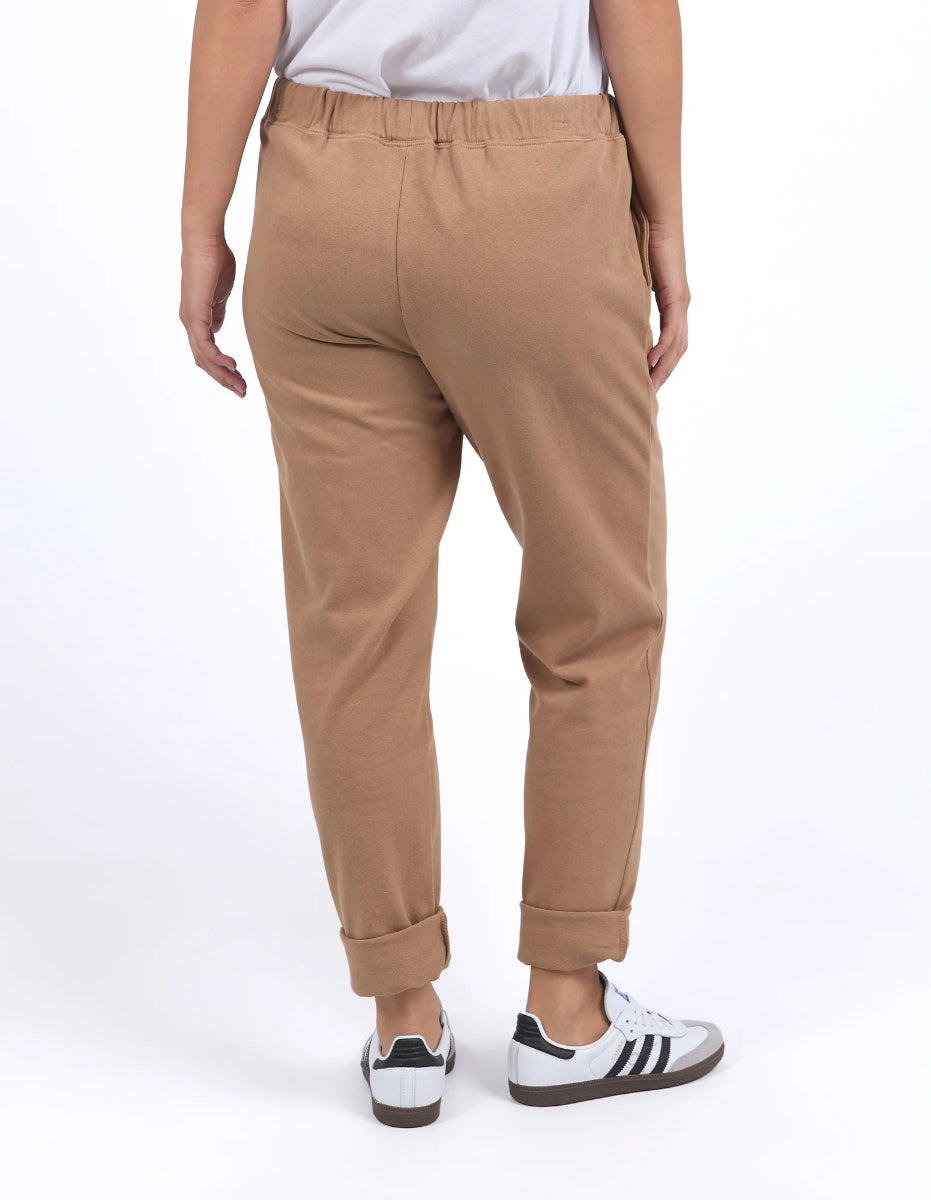 Wearing casual monday coconut pants relaxed tapered fit, elastic drawsting waistband side pockets, plain background