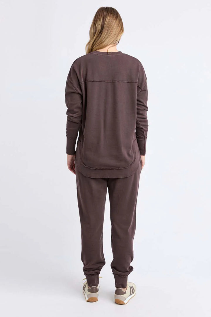 Person wearing a brown tracksuit on a white background