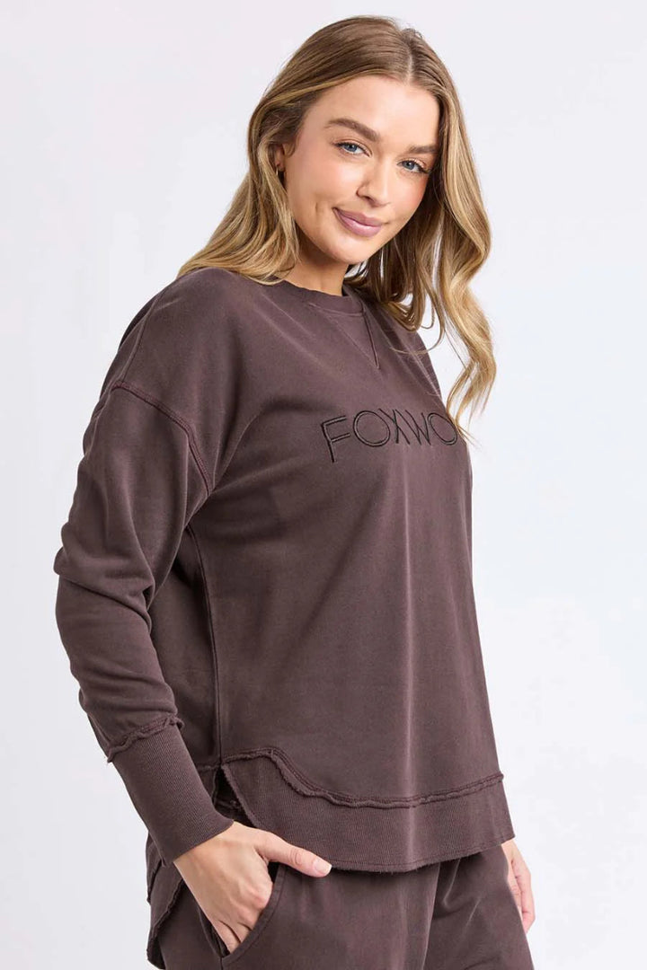 Woman wearing a brown sweatshirt with 'FOX' logo on a white background