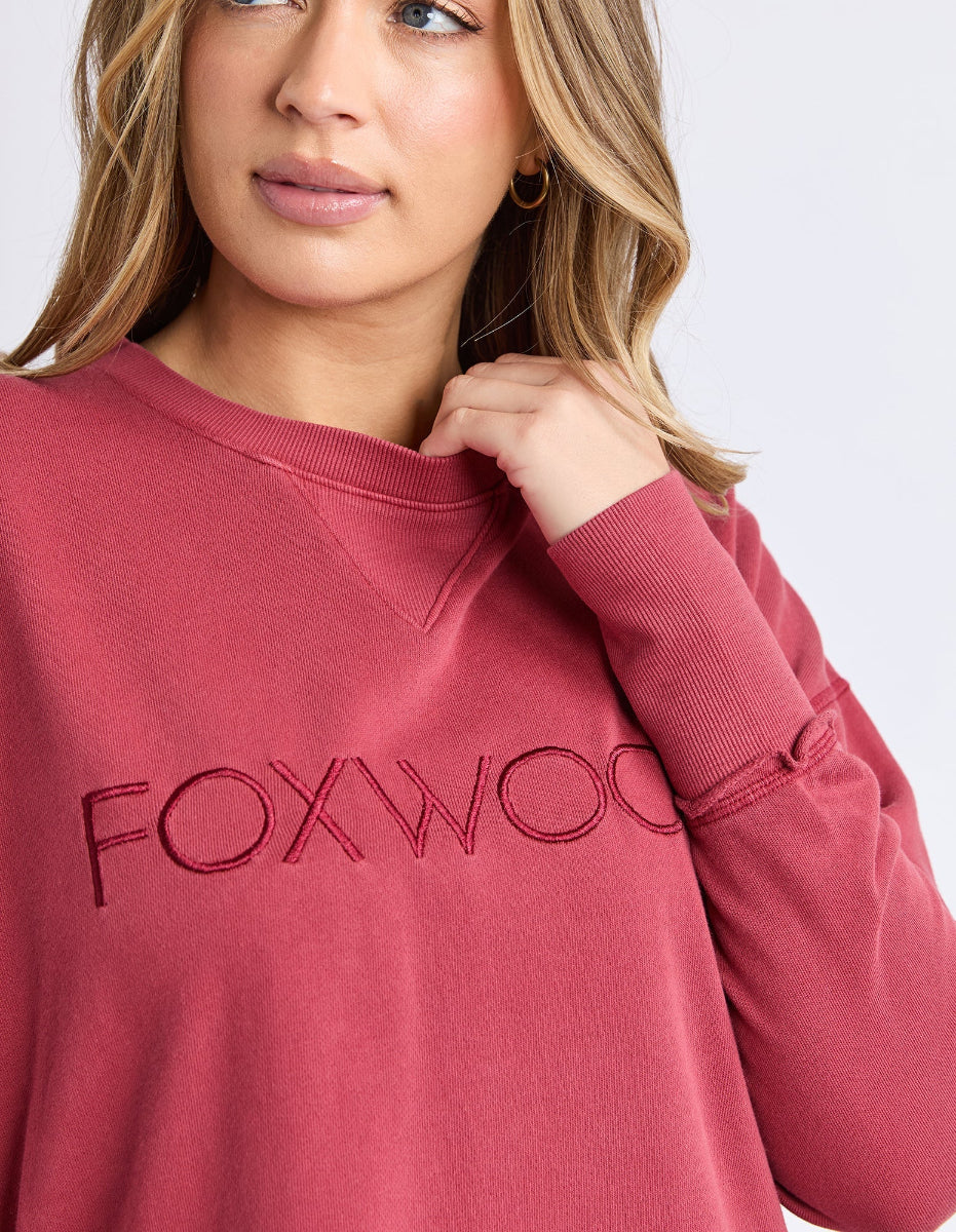 Close-up of rust FOXWOOD logo sweatshirt.