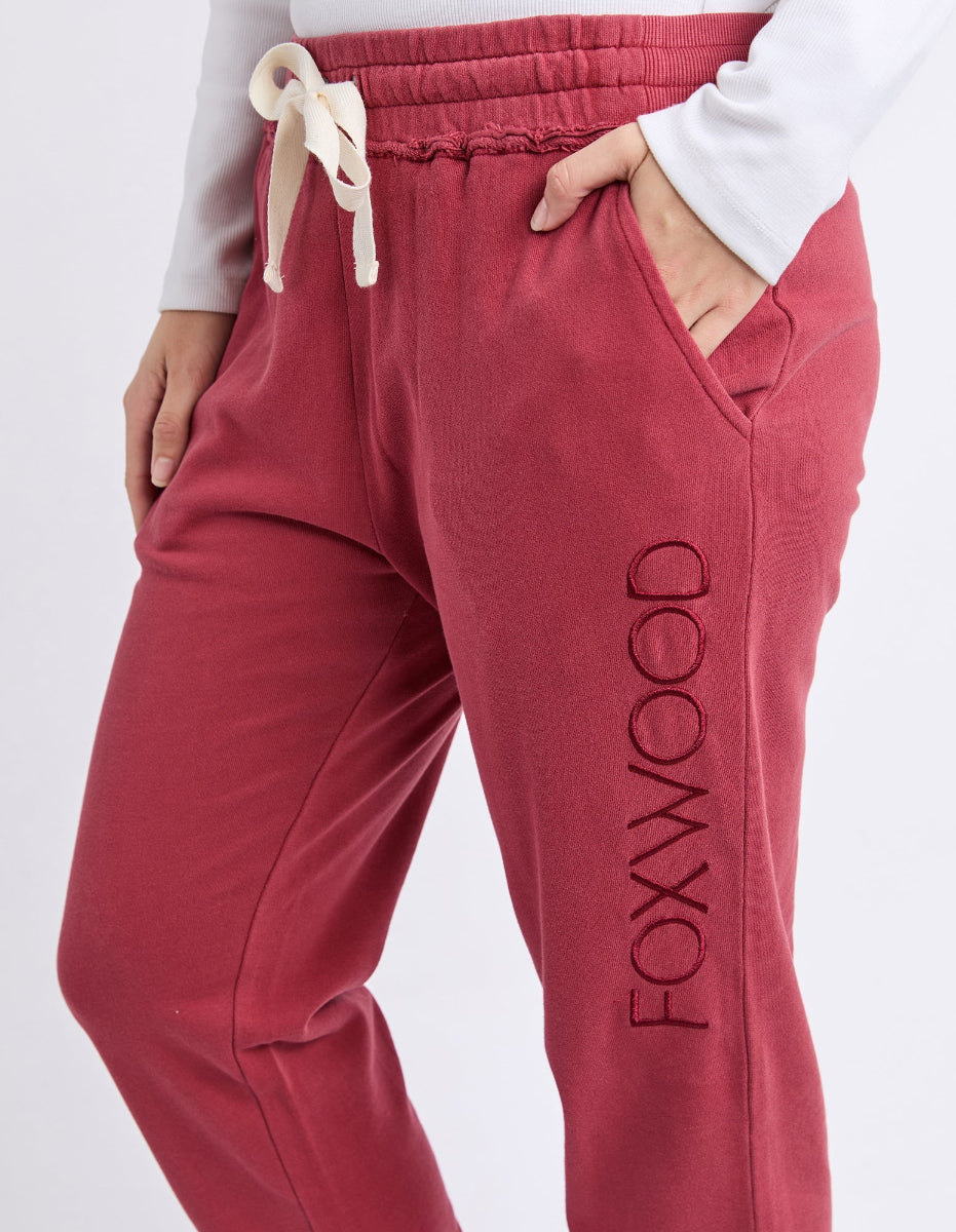 Close-up of rust Foxwood track pants with drawstring waist and side pocket.