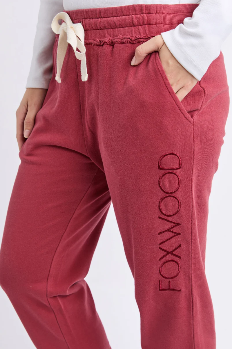 Red sweatpants with 'FOXWOOD' branding on a white background