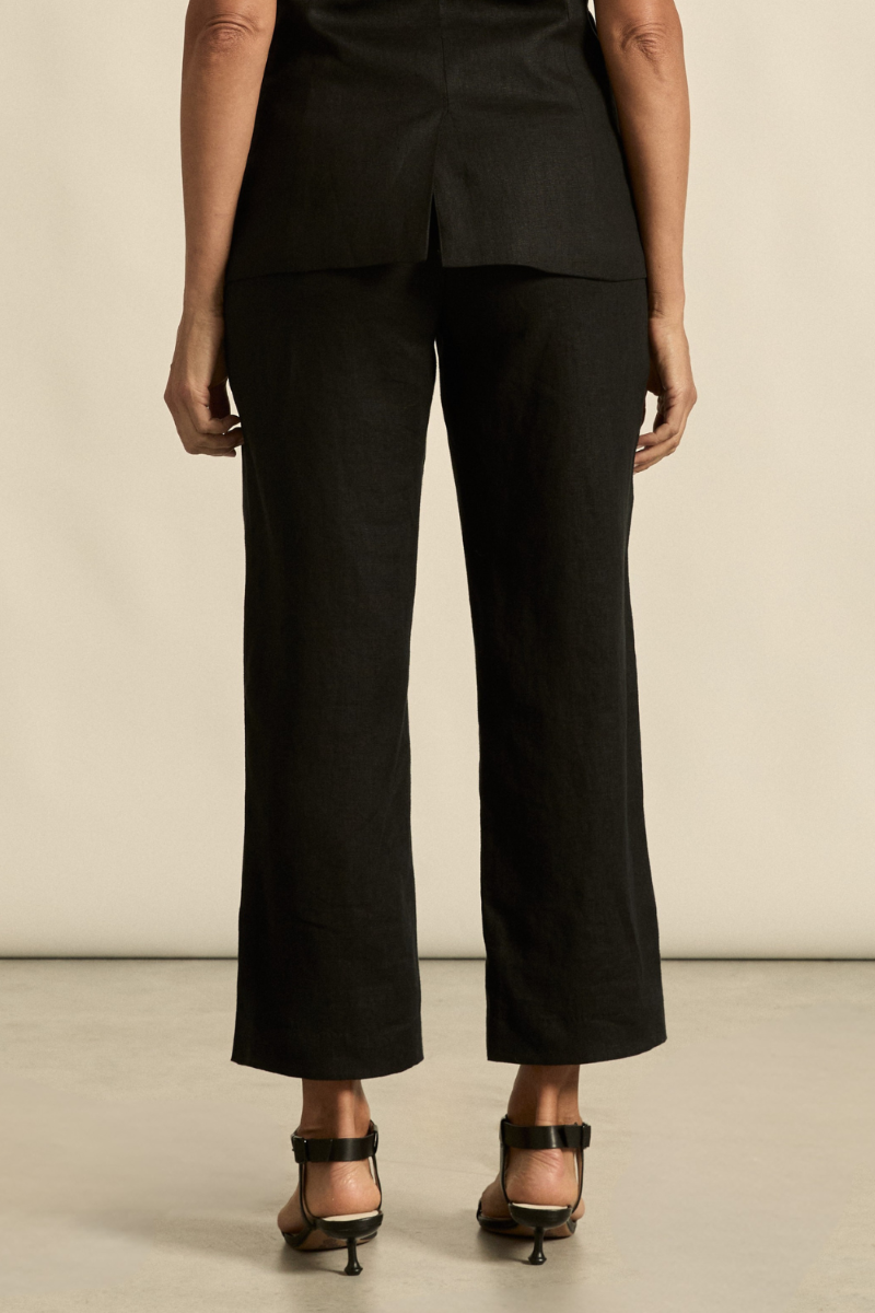 This back view of the Heed Pant in black highlights the tailored fit, welt pockets, and smooth silhouette for a polished, versatile look.

