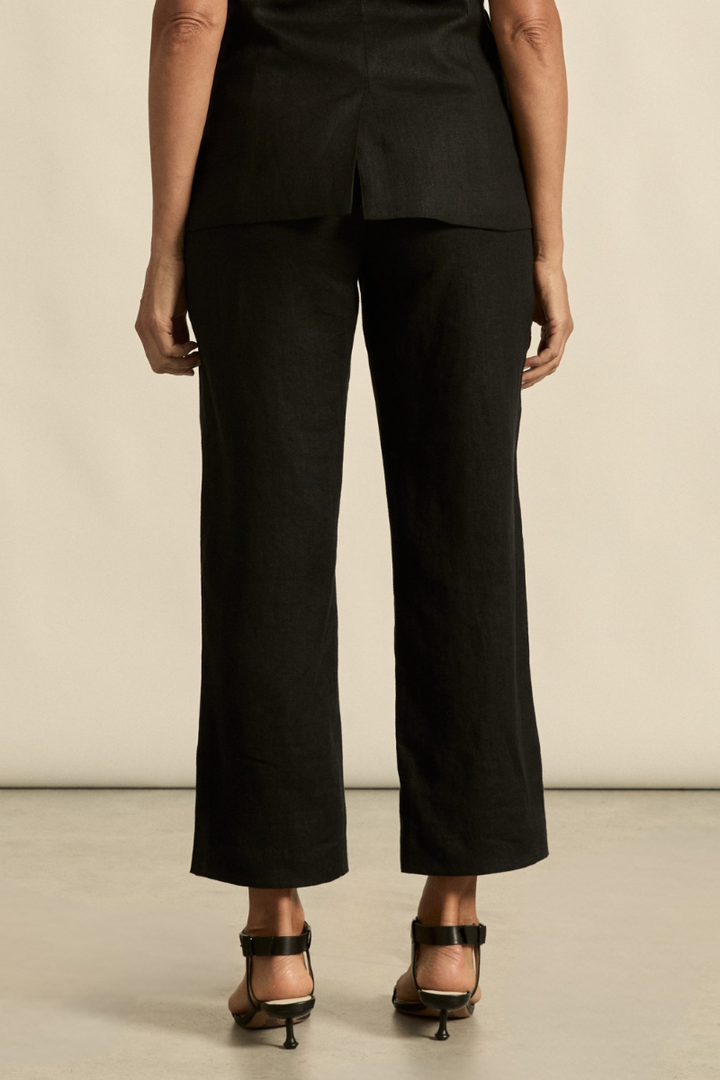 This back view of the Heed Pant in black highlights the tailored fit, welt pockets, and smooth silhouette for a polished, versatile look.

