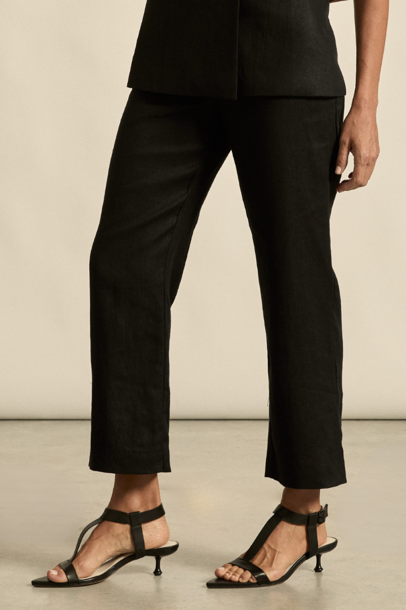 This close-up image of the Heed Pant in black highlights the smooth fabric texture, precise stitching, and clean waistband details.
