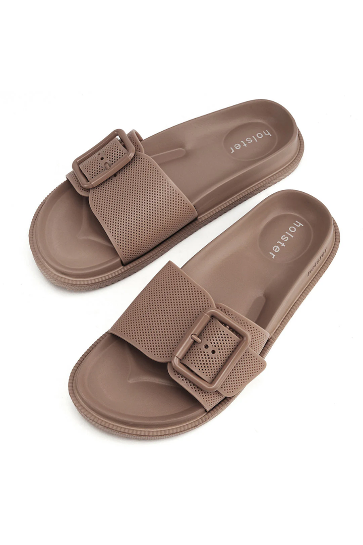 Pair of brown sandals with buckle design on a white background