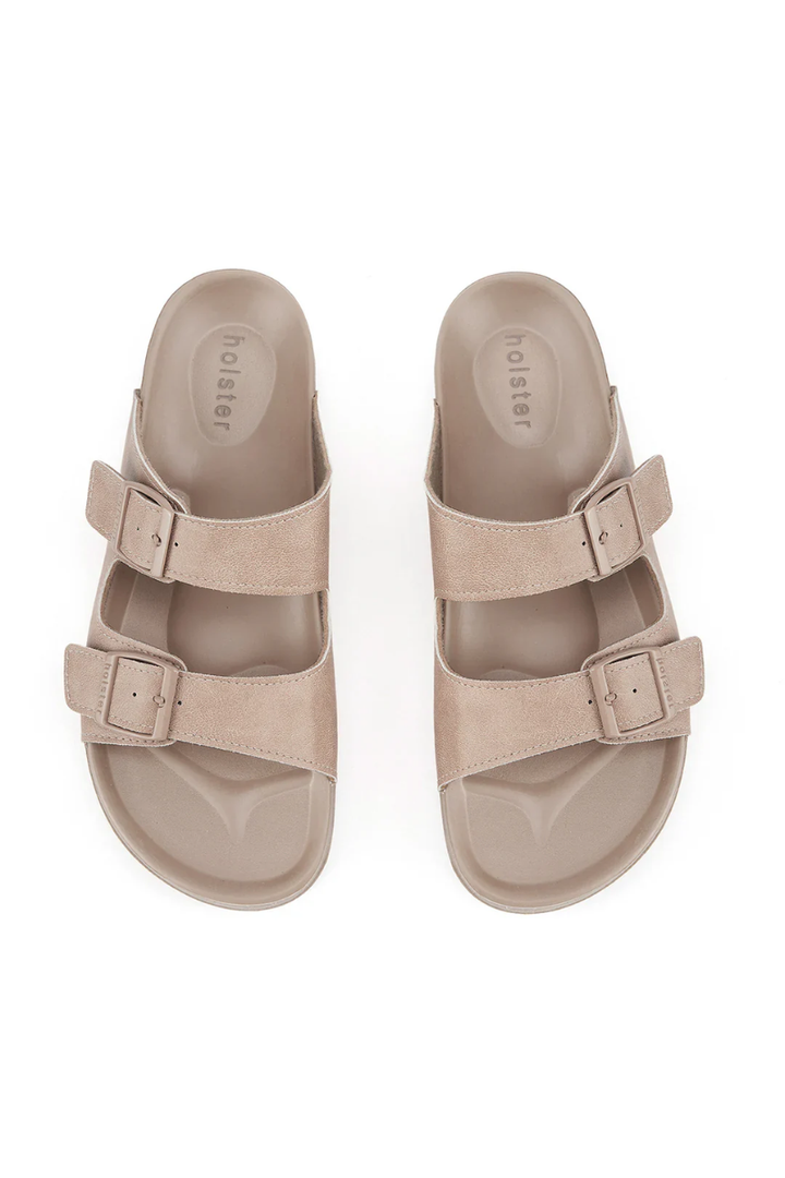 Pair of beige sandals with double straps on a white background