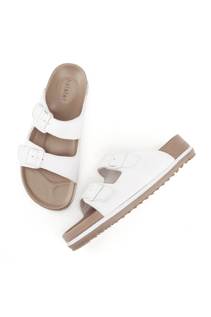 White sandals with brown soles on a white background