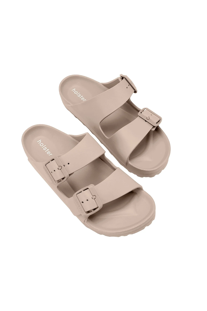 Pair of beige sandals with buckles on a white background
