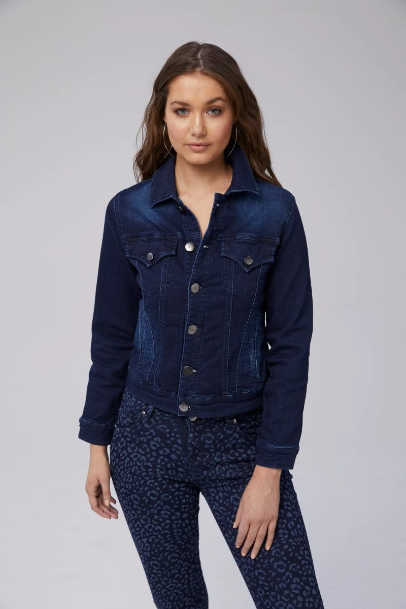Woman wearing a dark blue denim jacket and pants on a gray background