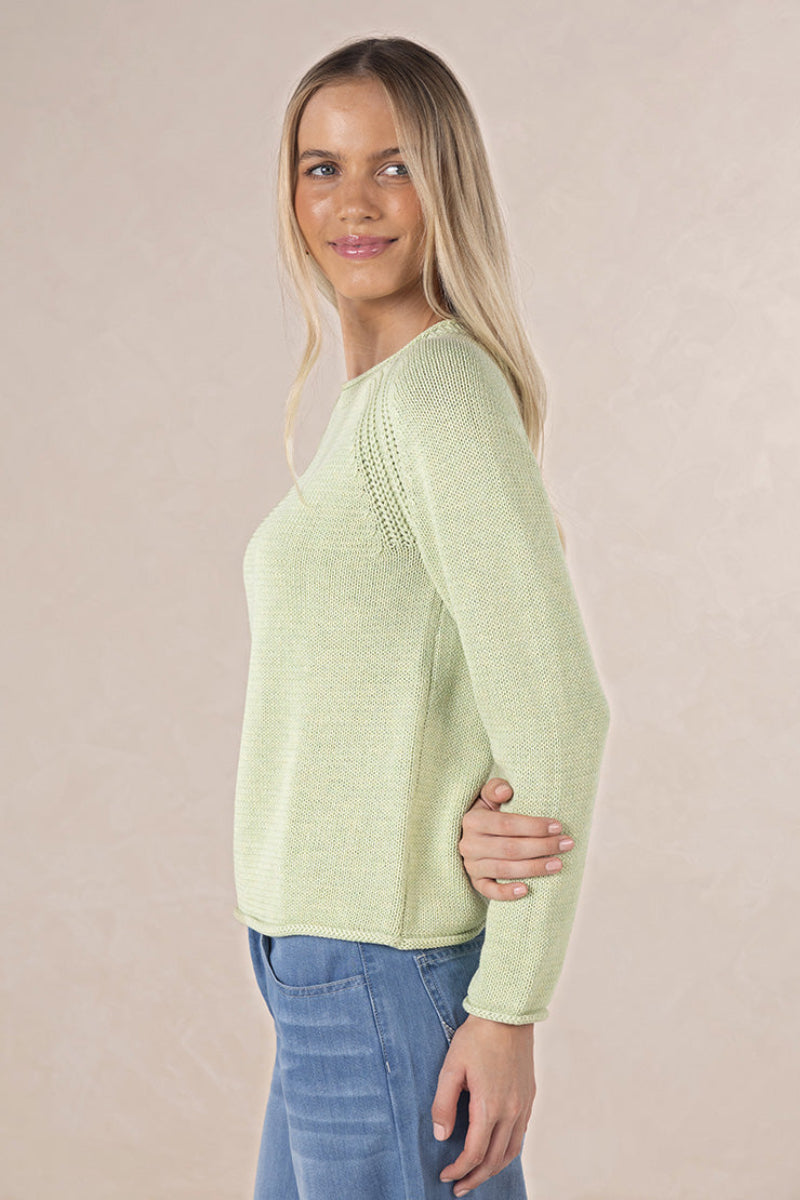 Woman wearing a light green sweater against a beige background