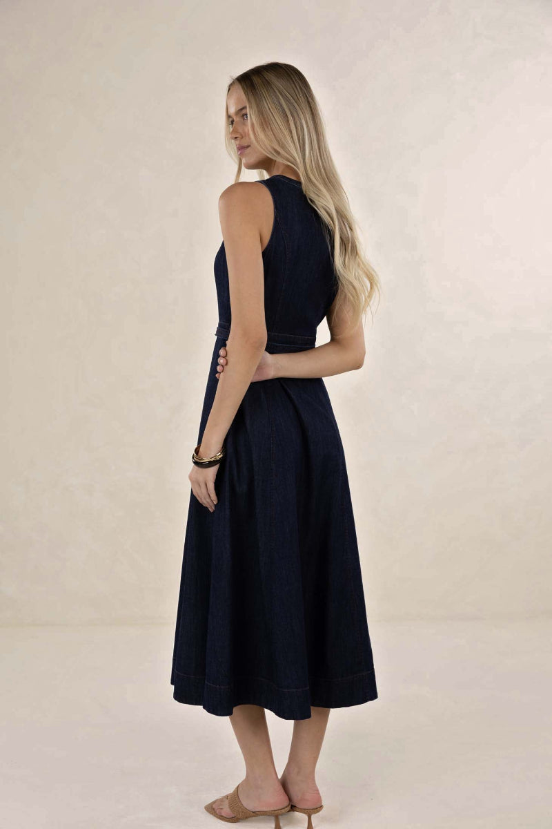 Woman wearing a navy blue dress against a beige background