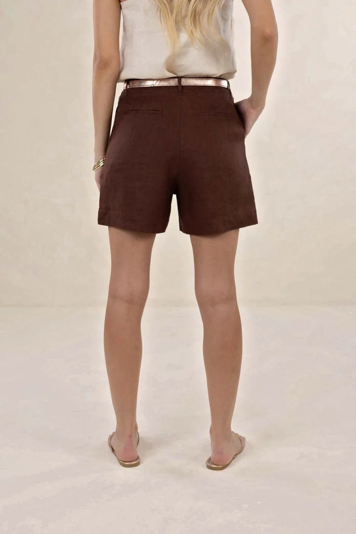 Person wearing brown shorts on a plain background