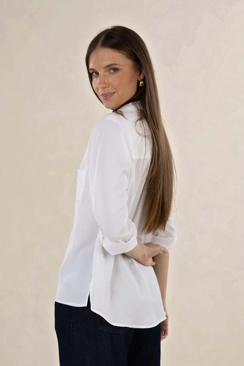 Woman wearing a white blouse against a beige background