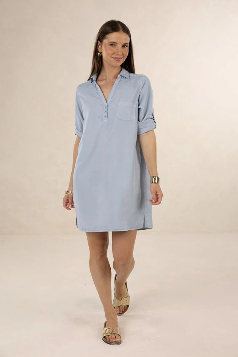 Woman wearing a light blue dress on a beige background