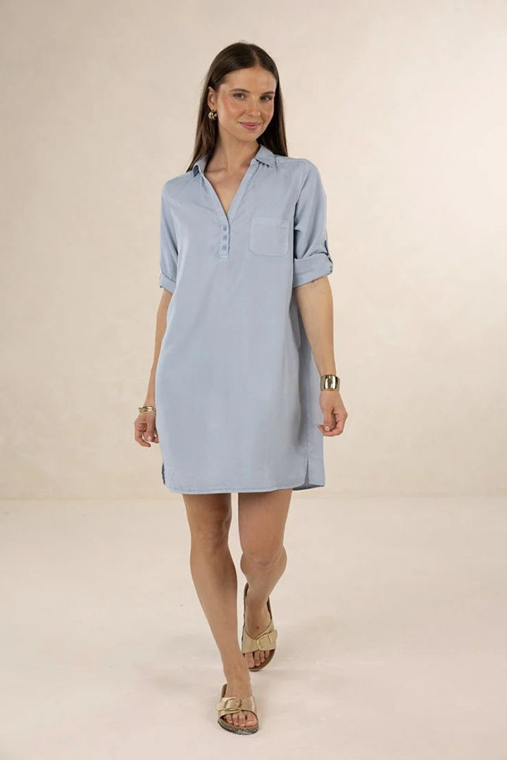 Woman wearing a light blue dress on a beige background