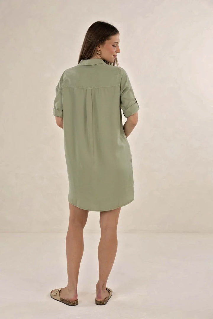 Woman wearing a green dress against a plain background