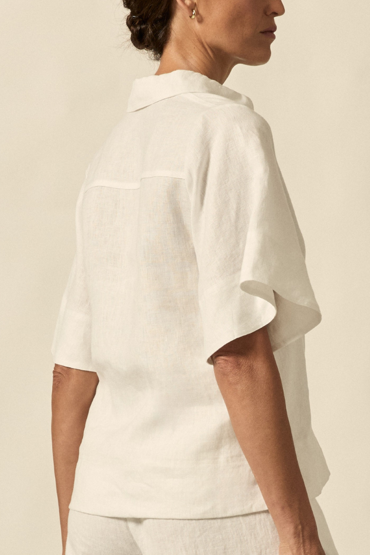 This close-up back view of the Insinuate Top in Porcelain showcases the smooth fabric texture, precise seam work, and elegant finish of the neckline.
