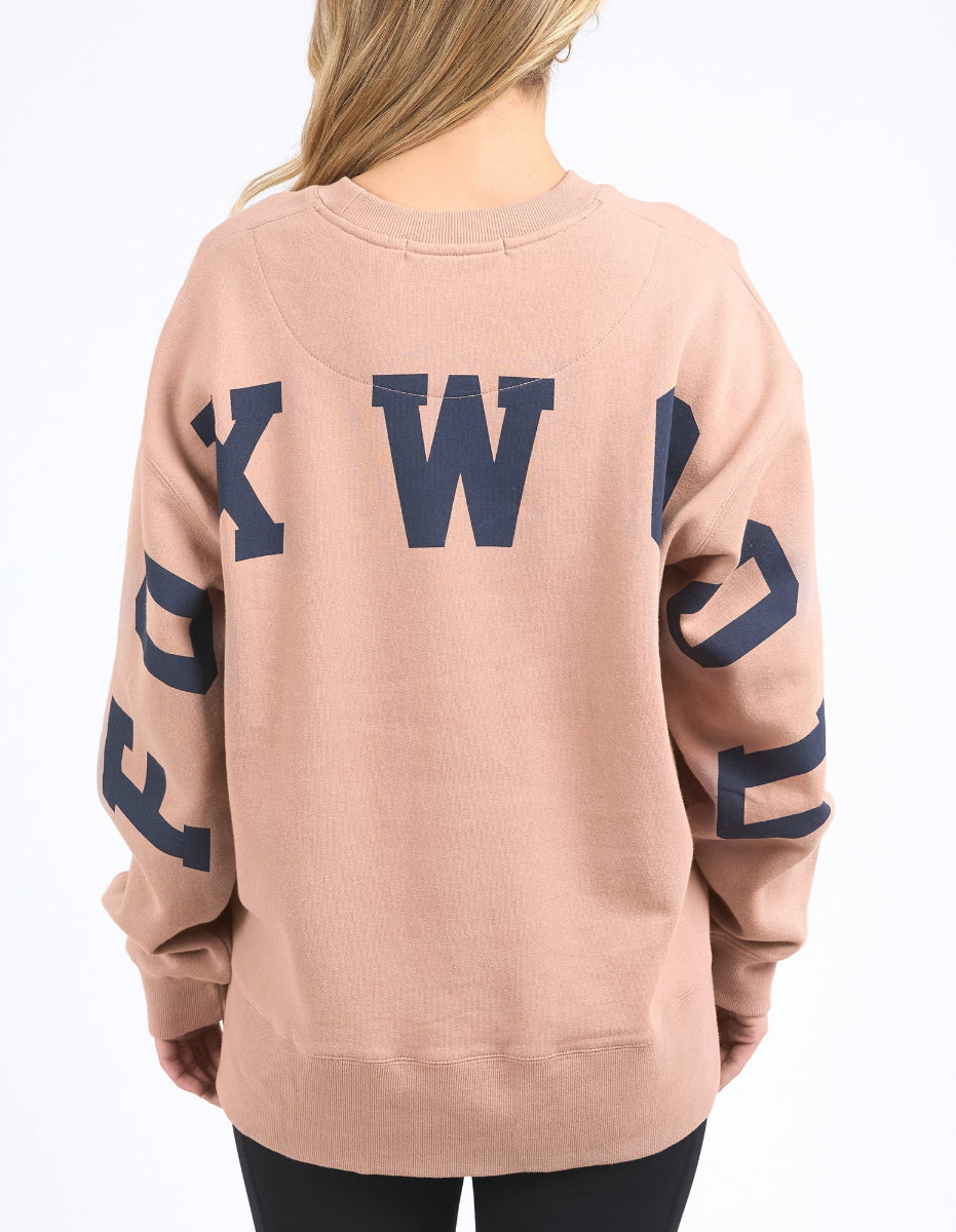 Women wearing a relaxed fit tan interval crew sweatshirt in a neutral background.