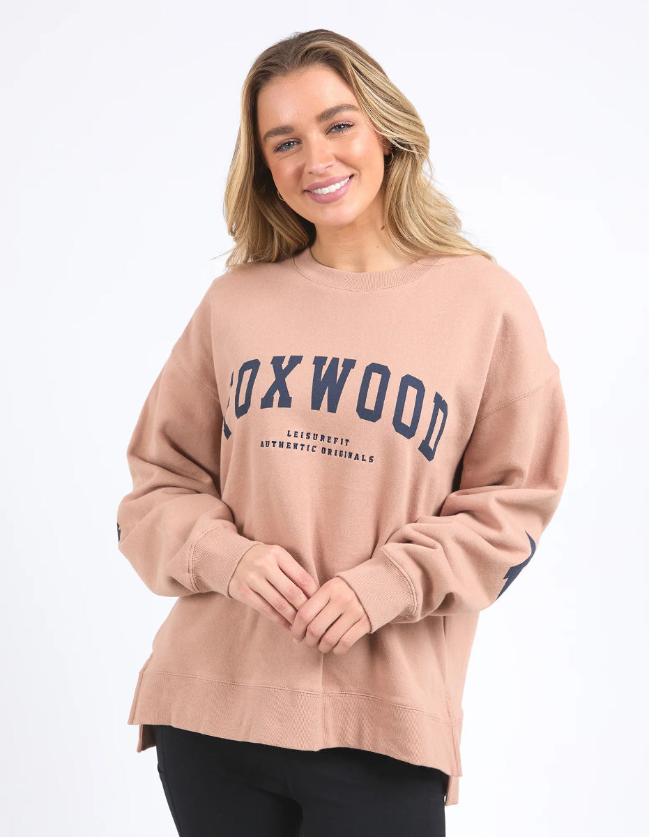 Women wearing a relaxed fit tan Foxwood interval crew sweatshirt in a neutral background.