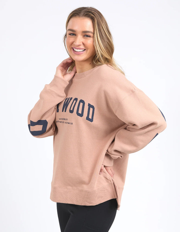 Women wearing a relaxed fit tan Foxwood interval crew sweatshirt in a against neutral background.