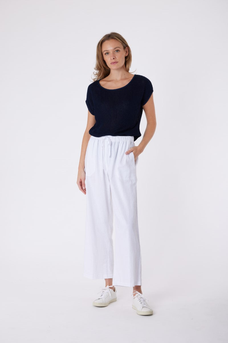 Model wearing the Carbon Isla Pant in White from Ivy Vibe, featuring a straight-leg fit, front pockets, faux back pockets, and an elastic waistband with drawstring.