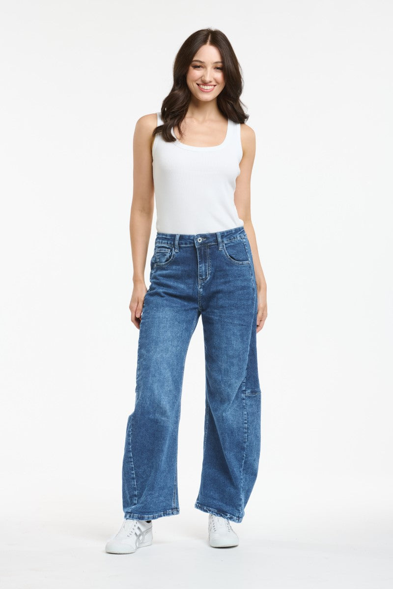 Woman wearing blue jeans and a white top on a white background