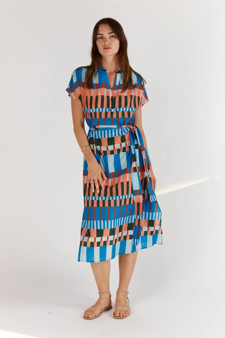 Woman wearing a colorful patterned dress on a white background