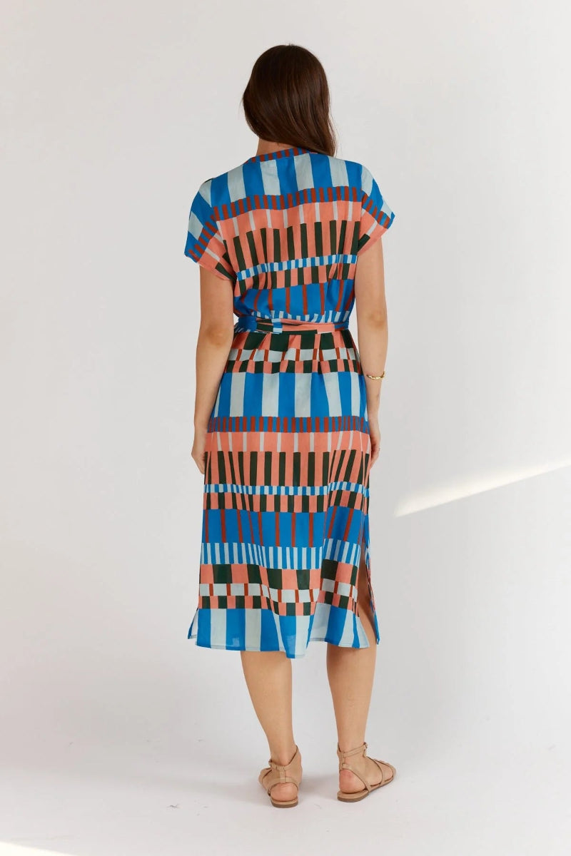 Woman wearing a colorful patterned dress on a white background