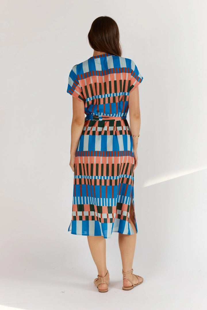 Woman wearing a colorful patterned dress on a white background