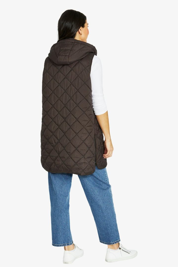 Person wearing a brown quilted vest on a white background