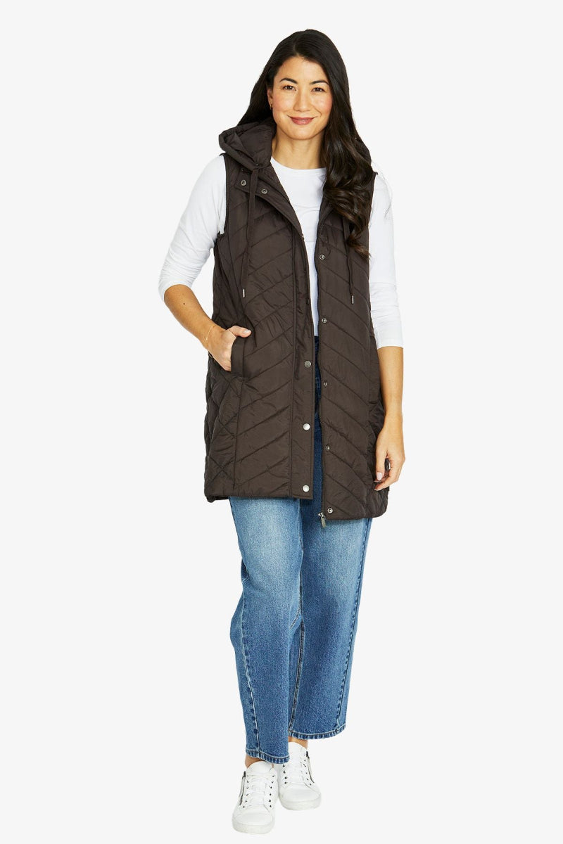 Woman wearing a brown quilted vest on a white background