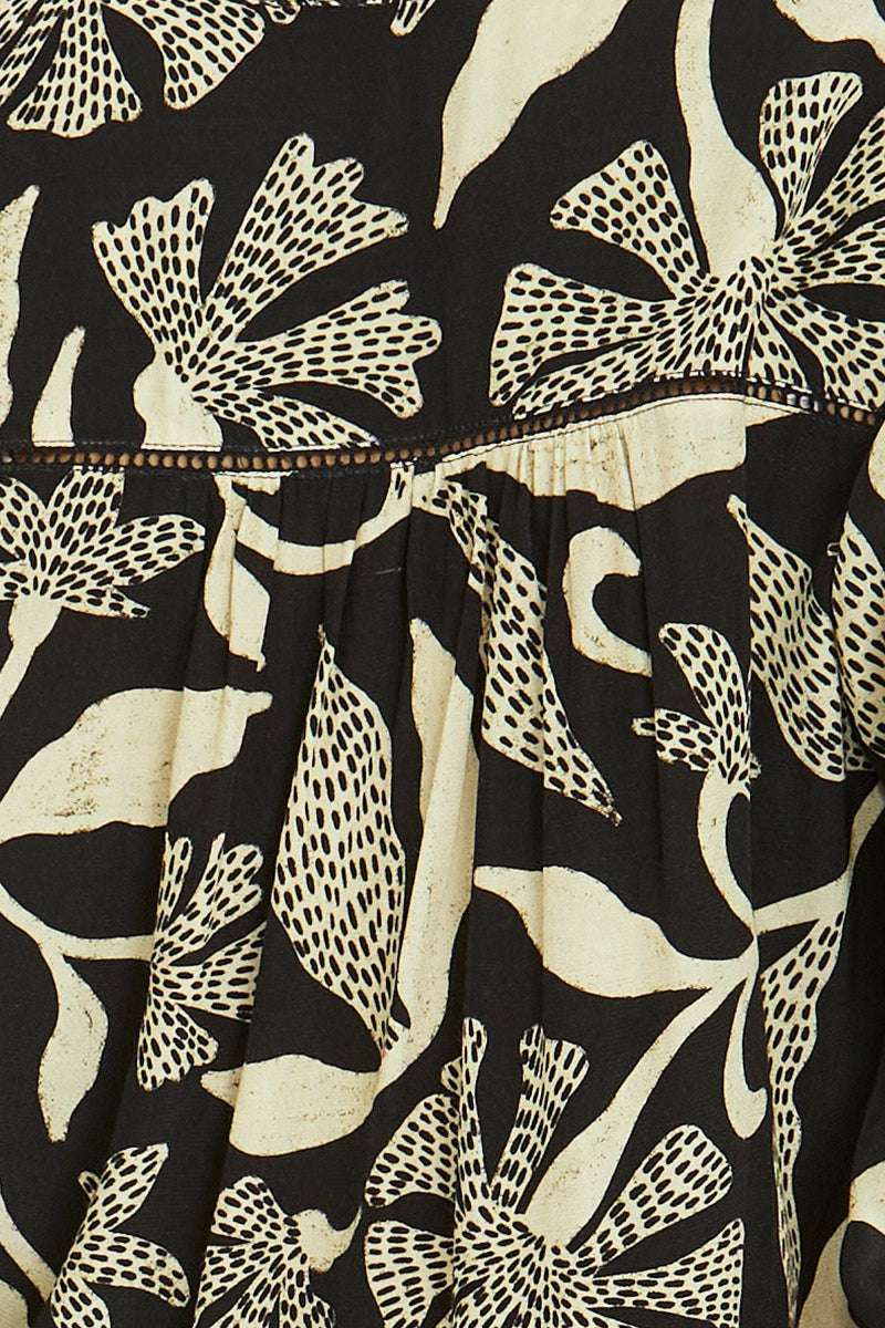 Close-up of a black fabric with beige floral pattern