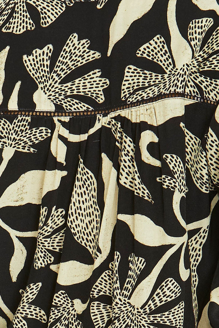 Close-up of a black fabric with beige floral pattern