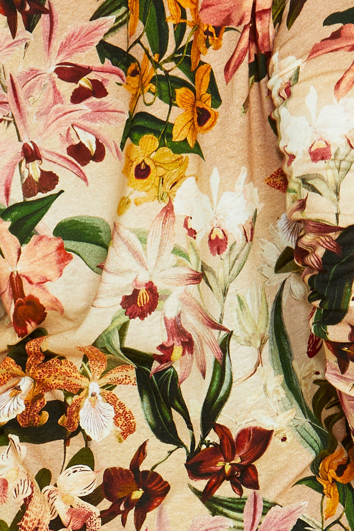 Close-up of a floral fabric pattern with various flowers on a beige background