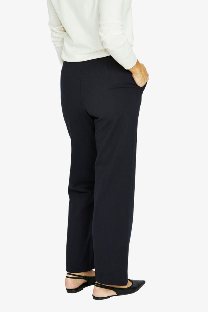 Person wearing black pants and a white top on a white background