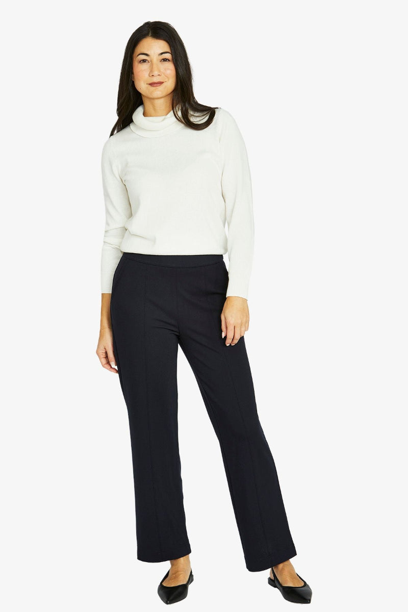 Woman wearing a white sweater and black pants on a white background