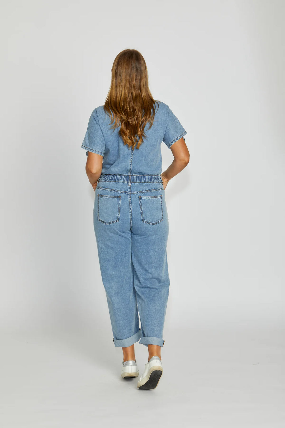 Person wearing a blue denim outfit on a white background