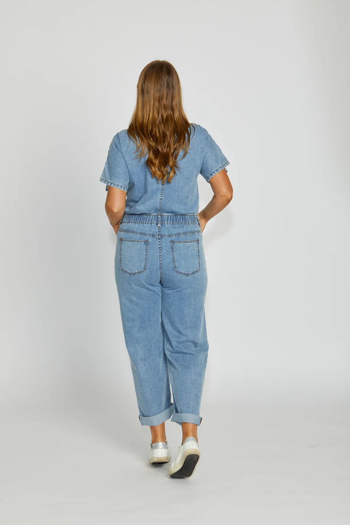 Person wearing a blue denim outfit on a white background