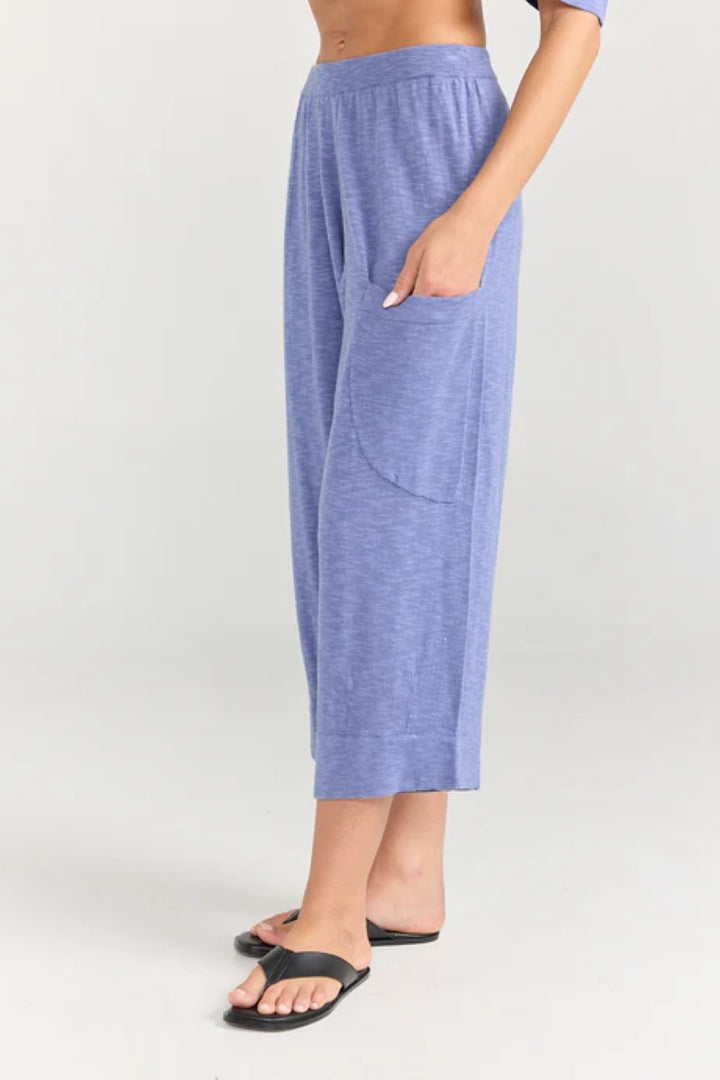 Person wearing blue lounge pants on a white background