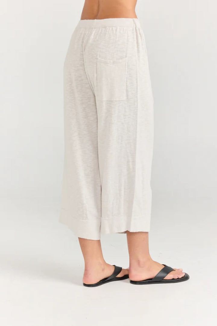 White linen pants worn by a person on a white background