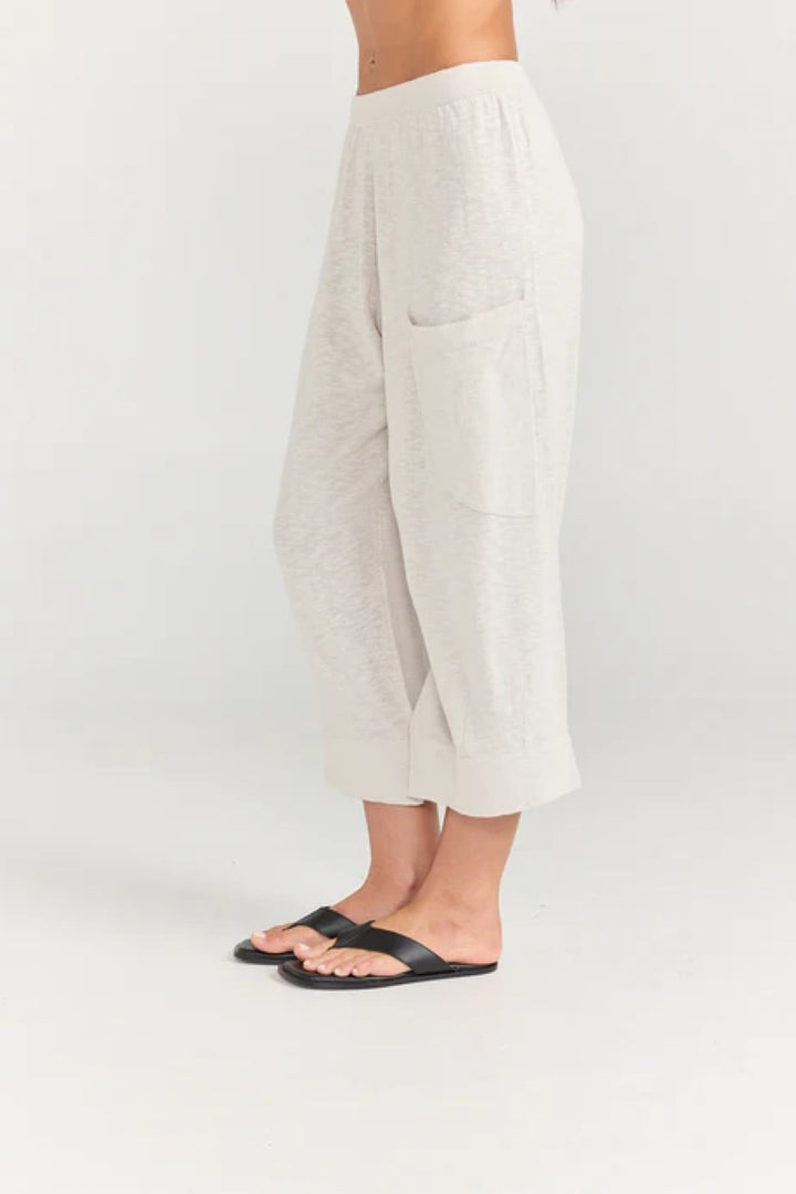 Beige pants worn by a person on a white background