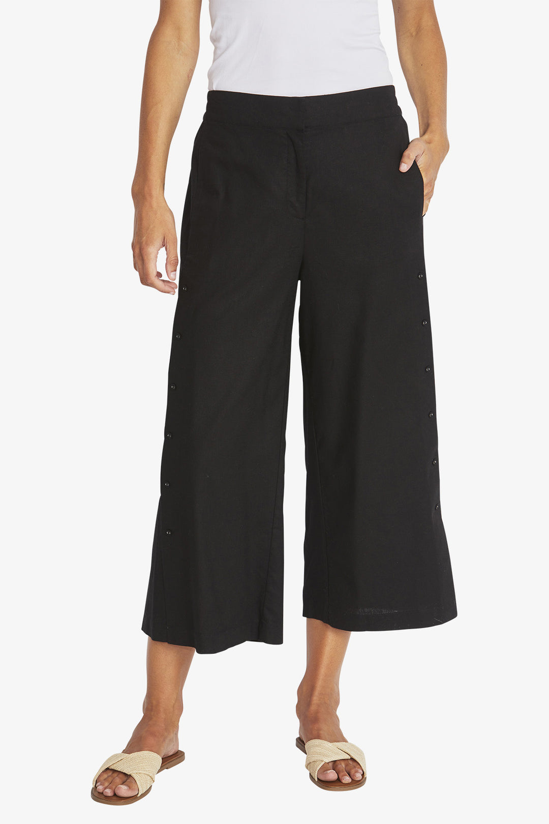 Person wearing black wide-leg pants on a white background